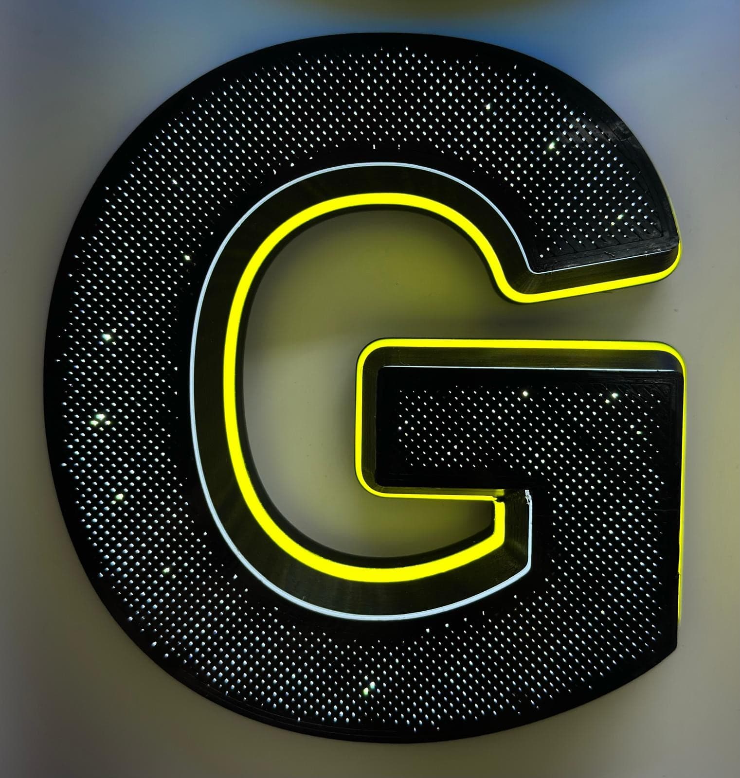 A black letter G with a sparkle-effect face and a lit yellow outline